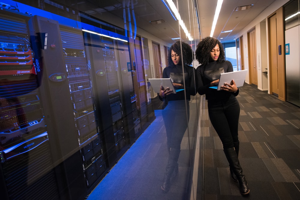 Denielle helping a client with a laptop in a calm, well-lit workspace